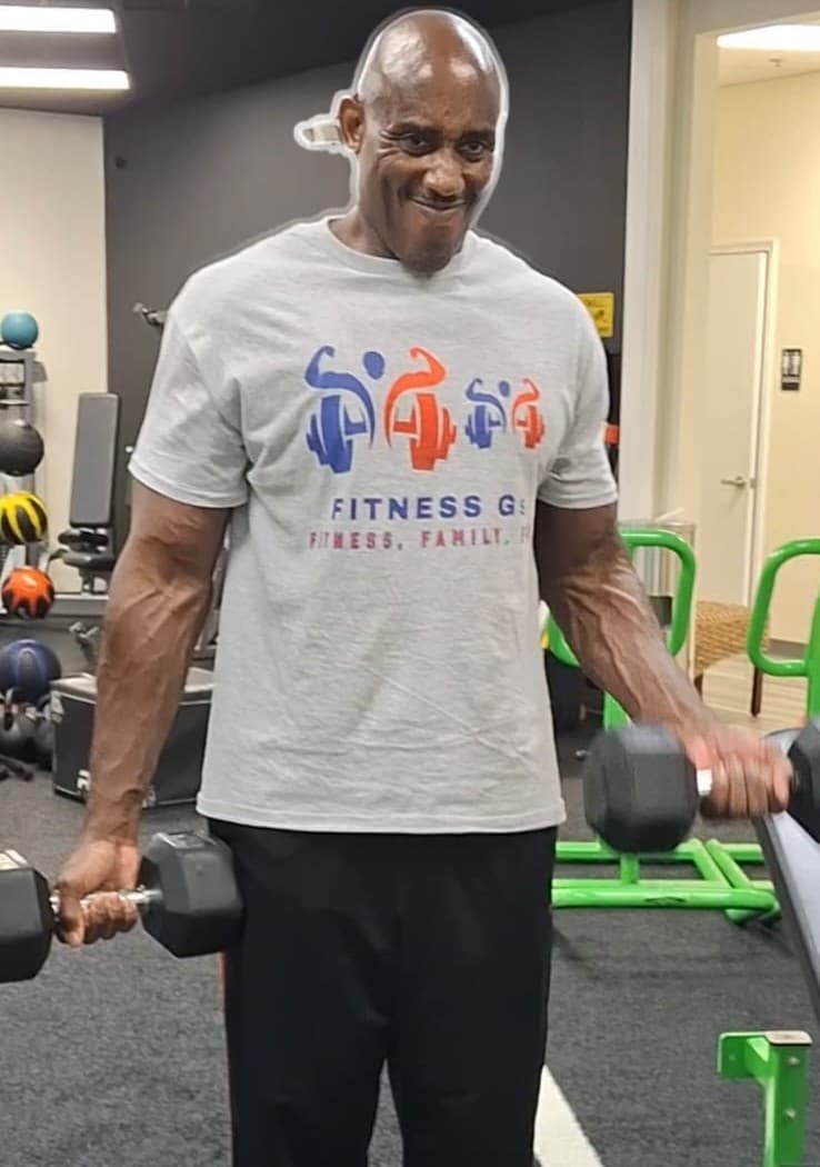 Coach Len training with dumbbells in a Fitness Gs shirt